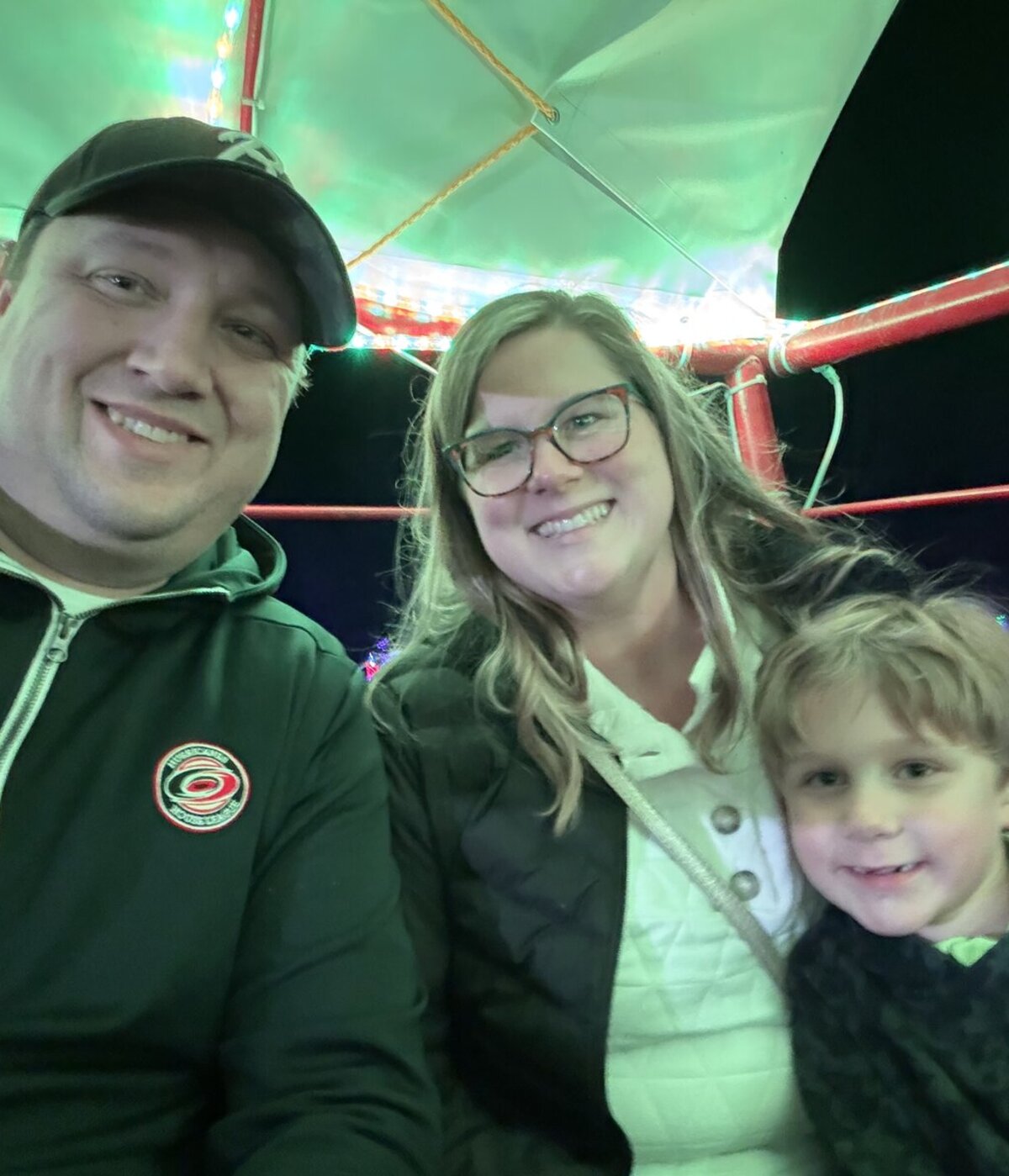 John, the craftsman behind 1789 Woodworks, with his wife and young son at an evening holiday lights event